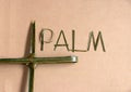 Palm leaf set cross to crucifix with palm leaf set to the word Ã¢â¬ÅpalmÃ¢â¬Â on the brown paper background. Royalty Free Stock Photo